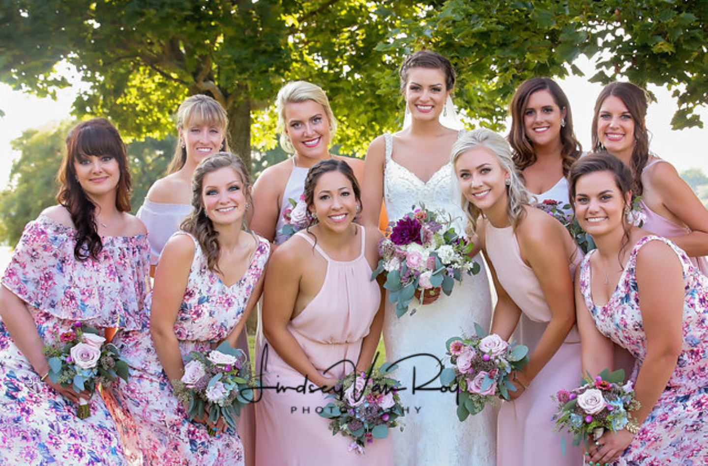 A bridal party with stunning airbrushed makeup in beautiful blush floral dresses