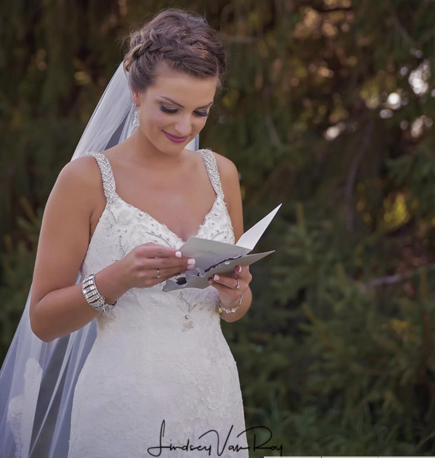 Gorgeous airbrushed makeup on bride reading card from groom