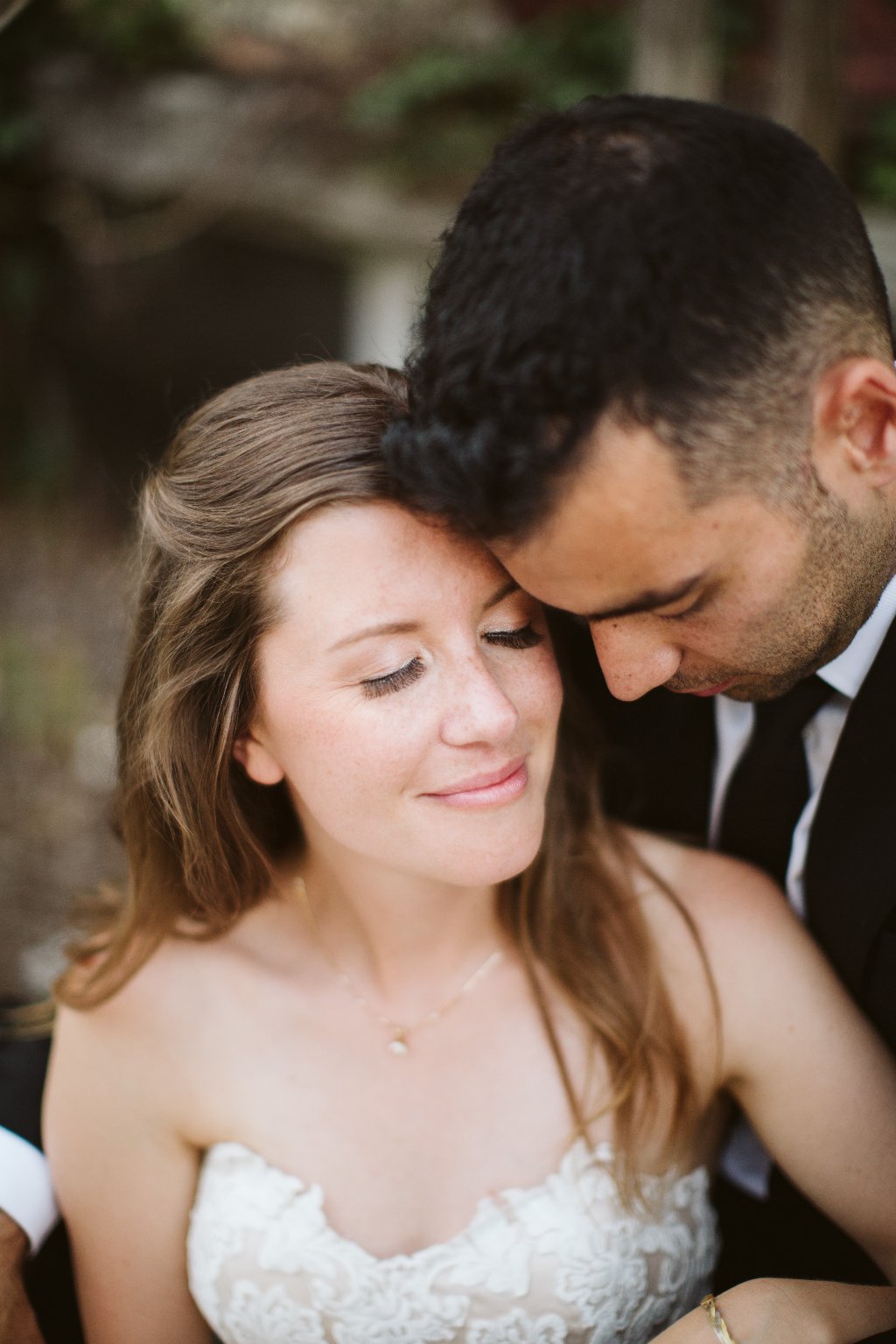 A sweet photo of a groom and a bride with stunning naturally beautiful makeup